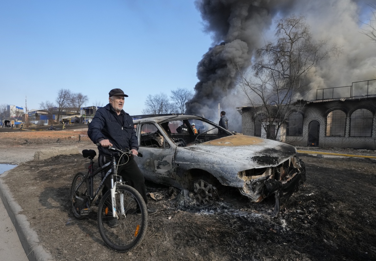 Un bătrân pe bicicletă, șocat de rămășitele bombardamentelor din Harkov