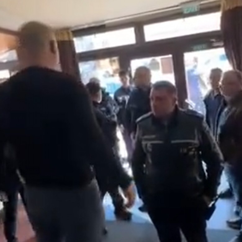 Omul de afaceri (cu spatele), blochează accesul oamenilor legii